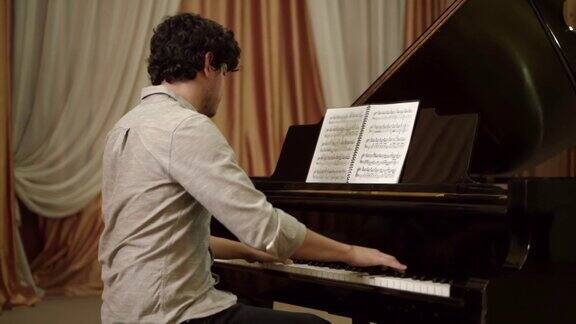 一个年轻人在音乐厅里弹钢琴