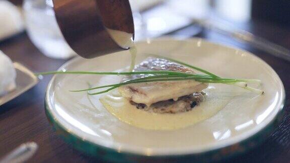 法式餐厅里往鱼上浇奶油酱