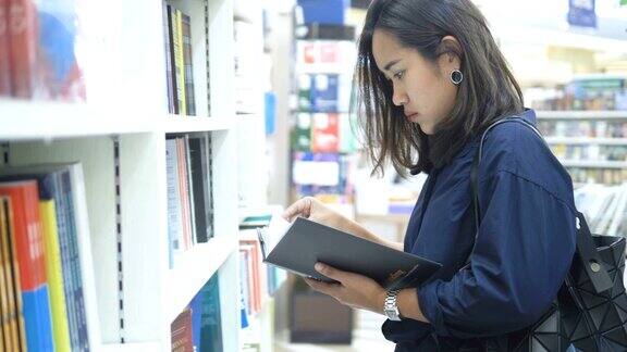 一位亚洲妇女在书店选购一本书