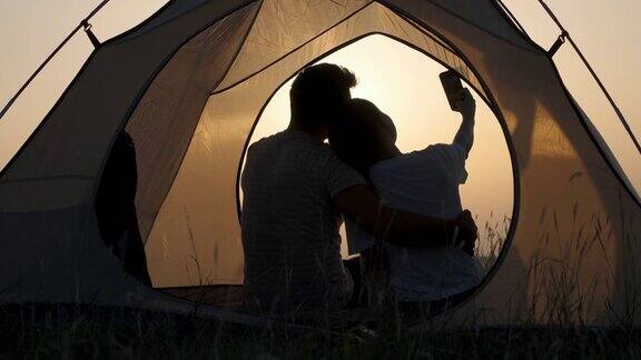 这对浪漫的情侣坐在帐篷里拍照慢动作