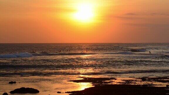 热带海滩与冲浪者在日落