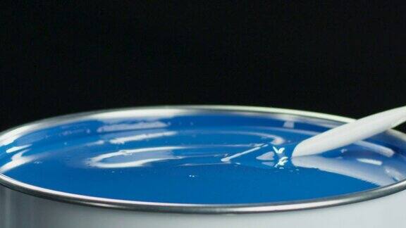 刷子掉进罐子里用亮蓝色油漆慢动作