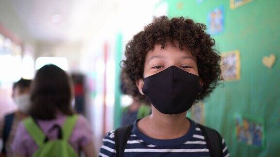 一个男孩在学校走廊里的肖像戴着防护口罩