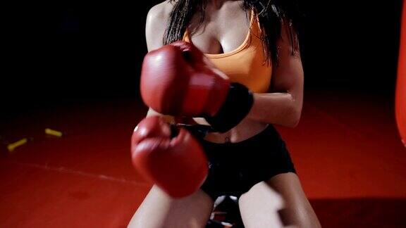 一个年轻的女拳击手在艰苦的锻炼后脱下拳击手套