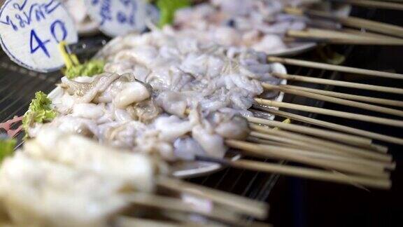 特写生鱿鱼串烤鱿鱼摊上的菜-泰国街头食品