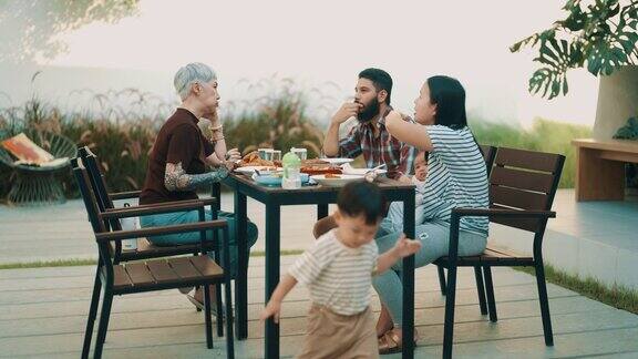 快乐的亚洲多代同堂的家庭在后院一起吃饭