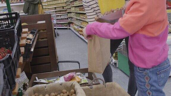 母女俩在超市购物把坚果装进袋子里