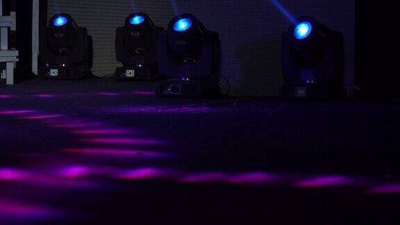 四个彩色放映机在舞台灯光农场明亮闪亮的舞台灯光闪烁着运动的娱乐聚光灯投射在黑暗中柔和的蓝色灯光照射在黑色背景上