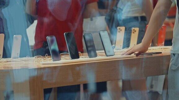 在一家电子产品商店的橱窗附近人们选择购买新智能手机的特写镜头