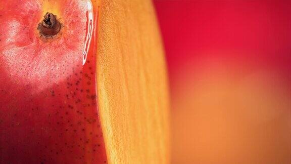 一滴芒果汁顺着旋转的半切芒果王的表面流下慢动作