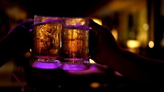 慢镜头FHD镜头特写敬酒和碰杯啤酒在酒吧和餐厅一起欢呼放松和饮料