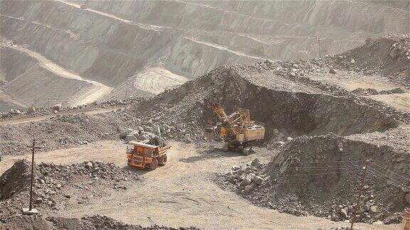 工业挖掘机和工人在采石场一种大型疲惫的工业挖掘机