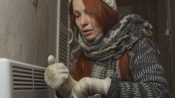 冻着的女人大概是为一个电暖器取暖暖器出了问题能源危机