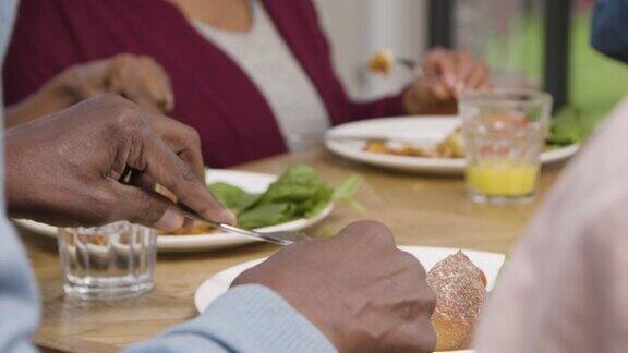 在家庭聚餐时男人用刀和叉吃饭
