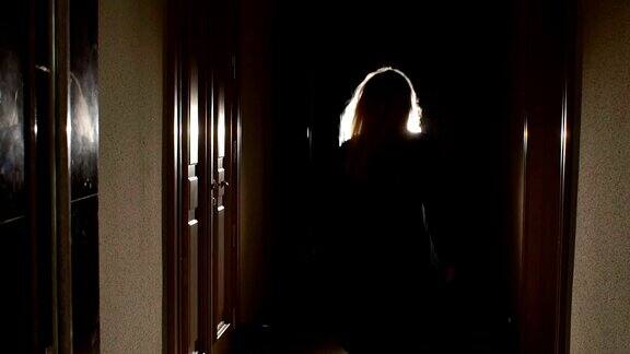 女孩在黑暗中穿过隧道的剪影