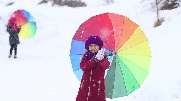 小女孩们在大雪中打着五颜六色的伞