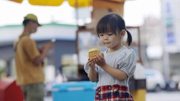 小女孩吃奶油泡芙很开心