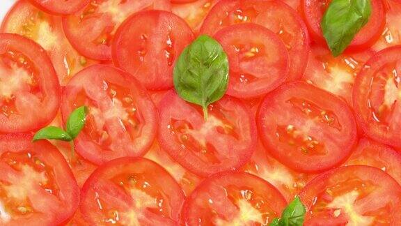 切成薄片的新鲜番茄配上新鲜罗勒叶就像番茄土豆片一样旋转作为背景准备披萨或蔬菜沙拉近距离观察番茄片