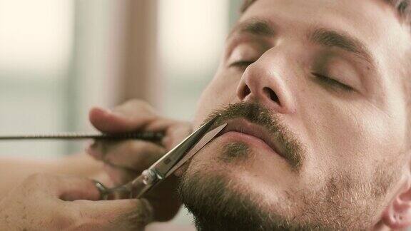 理发师用剪子给客户剪胡子