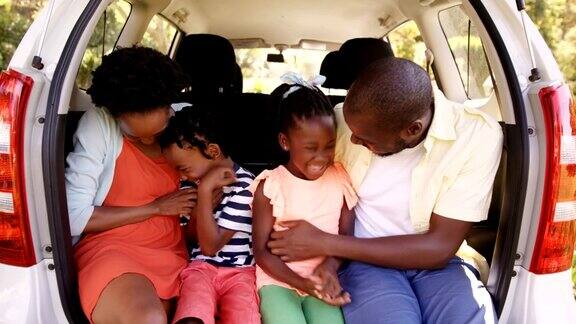 幸福的一家人坐在车里微笑着