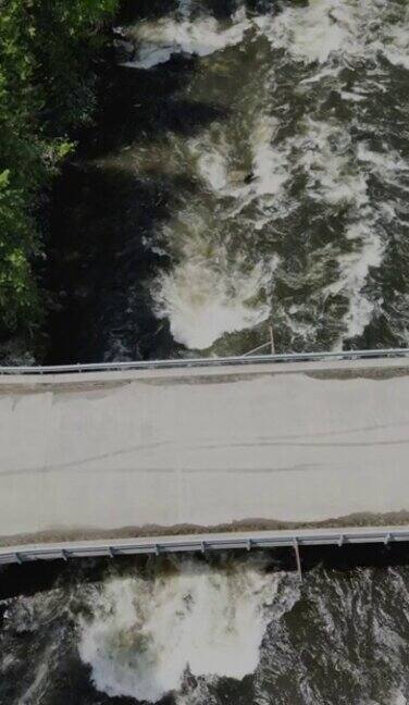 无人机在湍急的河流上拍摄了一座桥的垂直画面