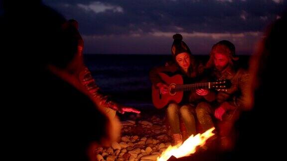 年轻的朋友们围着篝火听吉他