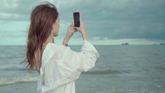 快乐的亚洲海滩女人自拍社交媒体与海滩