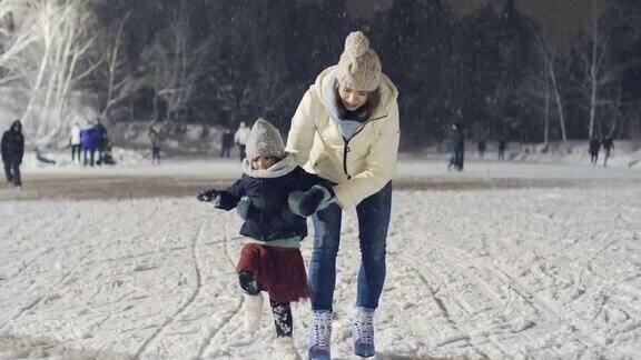  俄罗斯小女孩和妈妈雪地练习滑冰