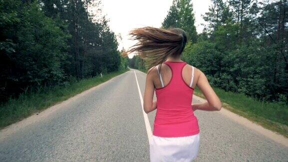 在森林里奔跑的年轻女子健康苗条的年轻女运动员跑步