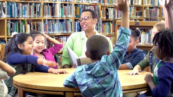 老师小学生在图书馆举手