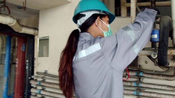 亚洲女技术员检查大楼内空调泄漏女性工程师联系
