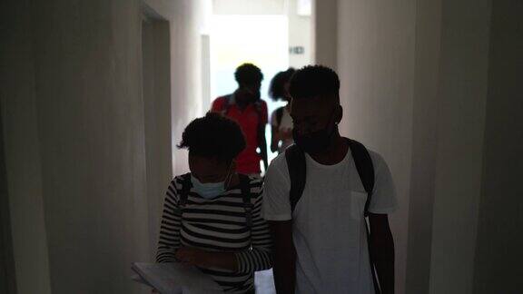 学生在学校走廊用笔记本