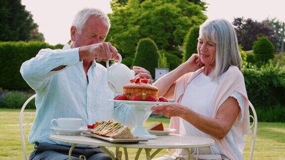 一对退休夫妇在家花园里享用下午茶