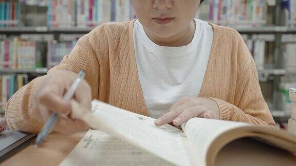 亚洲妇女在图书馆阅读和学习
