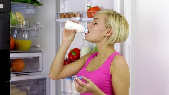 女人打开冰箱喝酸奶牛奶