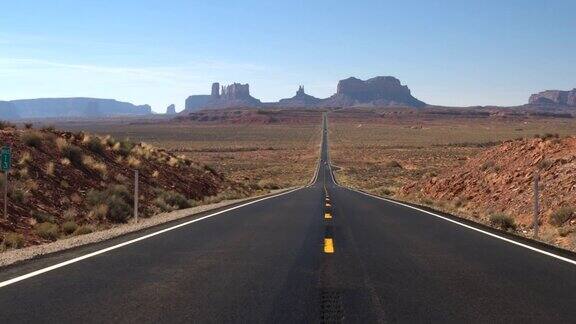 在阳光明媚的美国犹他州标志性的纪念碑谷笔直的道路