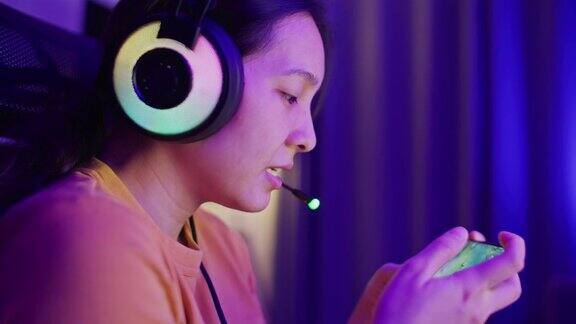 亚洲女性在家中客厅用智能手机玩网络游戏