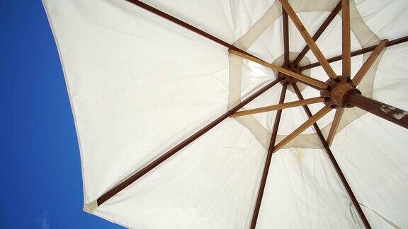 白色沙滩阳伞避暑伞下夏日明媚的蓝天