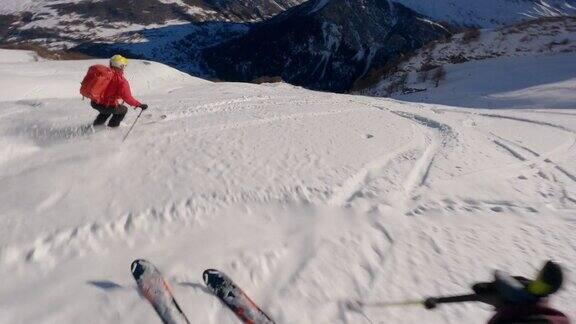 第一个人的看法滑雪者下降雪山在一个晴朗的日子