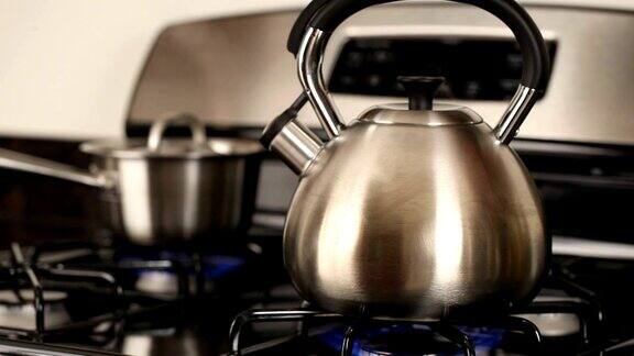 茶壶在炉子上沸腾蒸汽从壶嘴冒出来