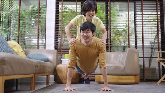 亚洲父亲和儿子在家里一起做俯卧撑