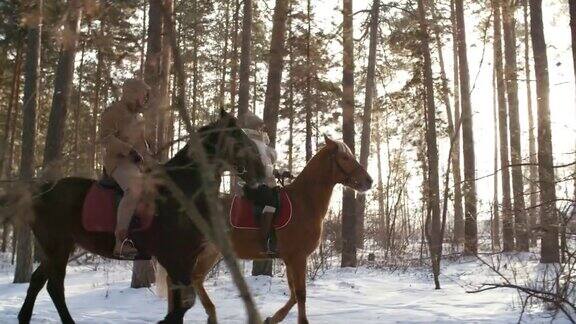 一对夫妇在森林里骑马在冬天的一天