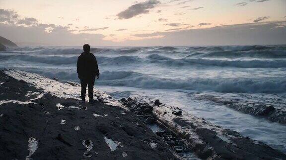 一个年轻人站在海边的剪影