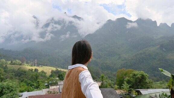 亚洲女子牵着男友的手在江道的观景点欣赏山上的山景