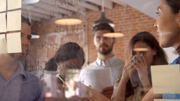 女商人开会时在玻璃屏幕上写下自己的想法
