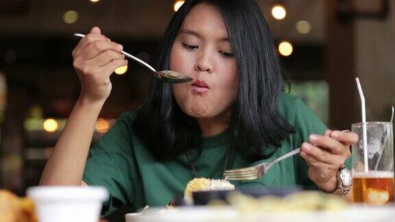 美丽的亚洲女人正在餐厅吃午餐主菜