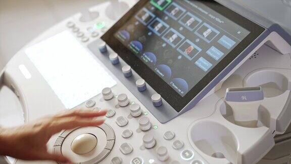 女医生的手按下传感器屏幕上的按钮在现代诊所操作超声设备的产科医生前视图