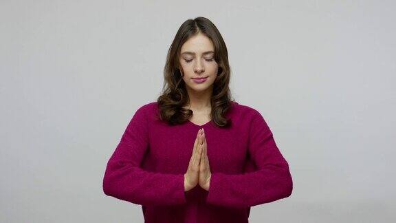 内心的平静、平衡积极冷静的黑发女人在套头衫牵手祈祷手势