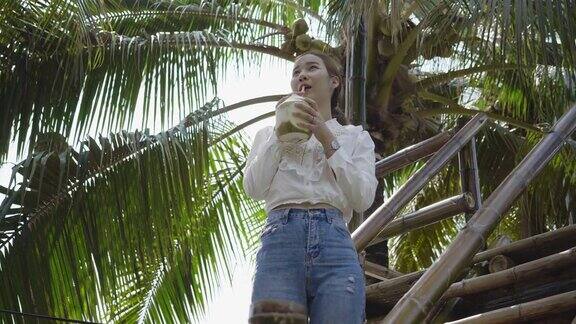 亚洲女孩在大自然喝椰子水