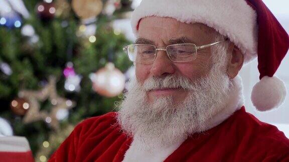 圣诞老人坐着笑着读一本有趣的书